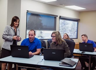 Instructor helping students learn Microsoft 365